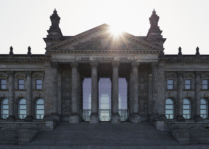 Sun shining behind Reichstag building Berlin Germany
