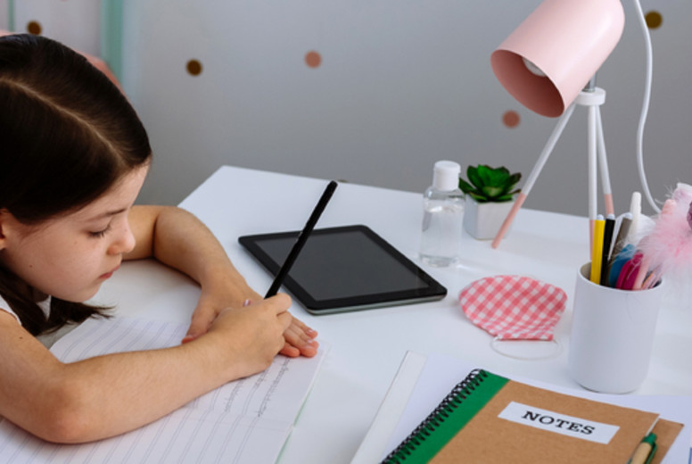 Girl studying at home with mask on table