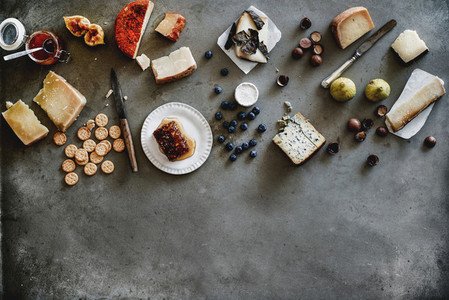 Variety of wine snacks and cheeses over grey background