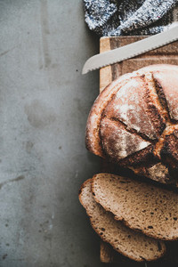 Freshly baked sourdough bread loaf and slices  vertical composition