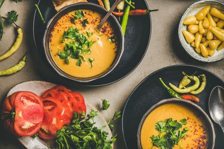 Flat lay of Turkish lentil soup Mercimek with parsley in bowls