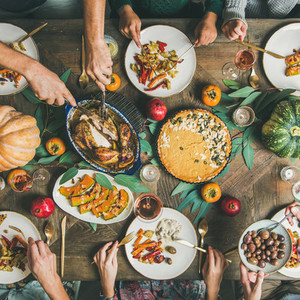 Friends feasting at Thanksgiving Day table with turkey  square crop