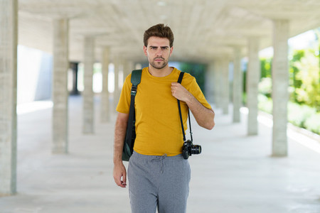 Millennial man taking photographs with a SLR camera