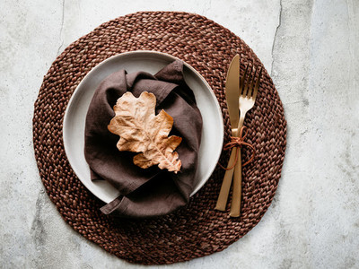 Top view of decorated table setting dish with fallen leaf  Thanksgiving or Autumn festive dinner concept