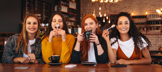 Crazy female friends hanging out at a cafe