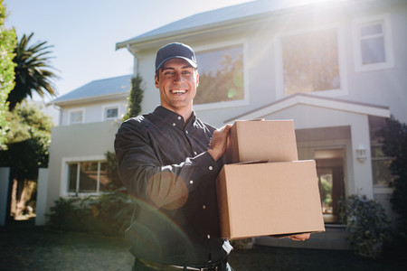 Smiling delivery person with parcel boxes