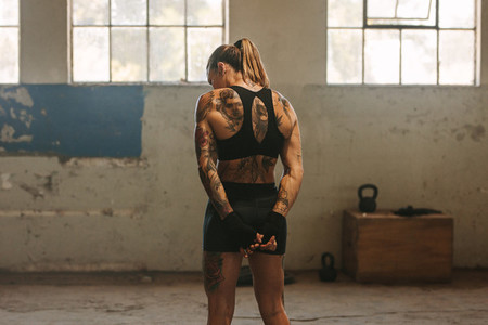 Tattooed woman boxer in old warehouse