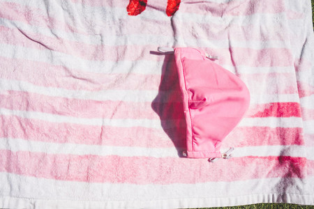 Pink face mask against a stripped pink towel