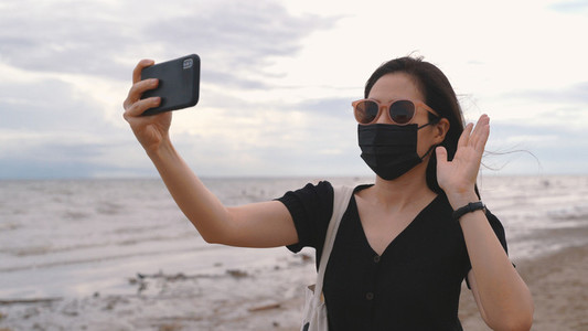 Young asian woman wearing medical mask and video call or facetim