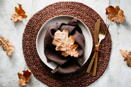 Top view of decorated table setting dish with fallen leaf  Thanksgiving or Autumn festive dinner concept