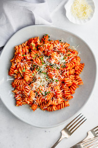 Top view of fusilli pasta with tomato sauce and parmesan cheese