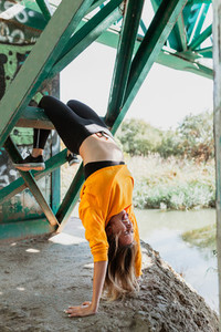 Woman does contortionism on an abandoned bridge