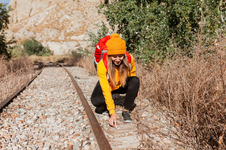 Woman trekking near train tracks picks up trash in nature  Environmental concept