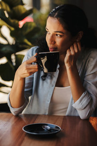 Woman sitting at cafe having coffee