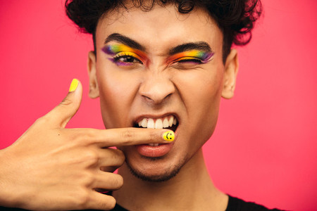 Transgender male biting his finger