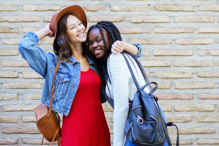Two friends hugging in urban background    Multiethnic friends