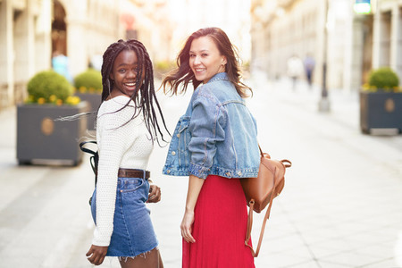 Two female friends having fun together on the street  Multiethnic friends