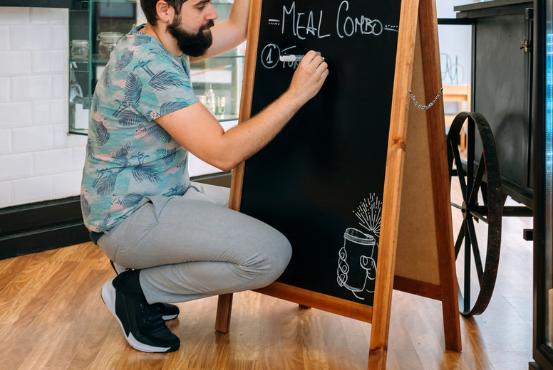 Young waiter writing the daily menu