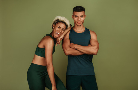 Fitness couple standing together on green background