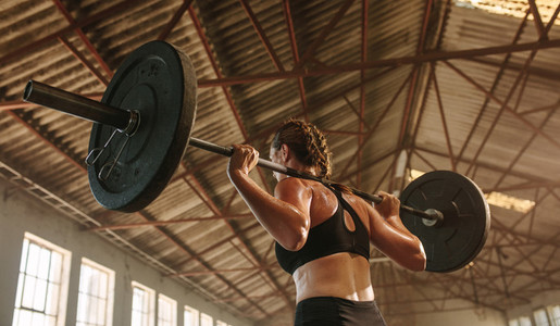 Strong woman exercising with barbell