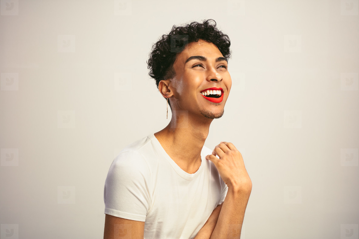 Feminine man wearing makeup laughing
