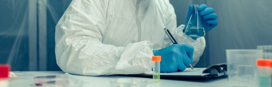 Scientist with protection suit investigating in the laboratory