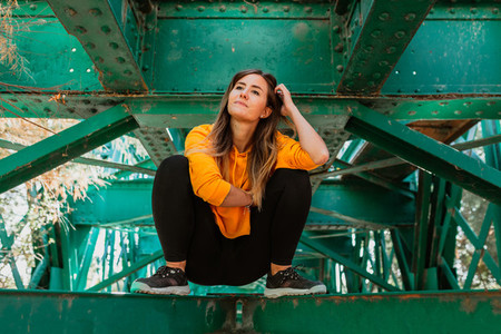 Woman has fun exploring an old  abandoned iron railroad bridge