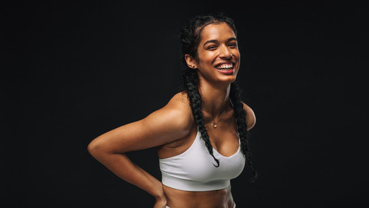 Smiling fit woman on black background
