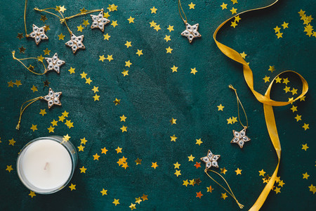 The New Year or Christmas festive flat lay with golden stars over a dark green background Top view copy space