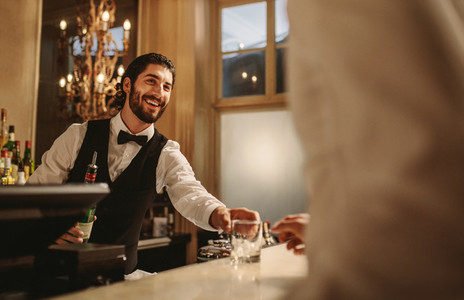 Bartender serving drinks to guest at a party