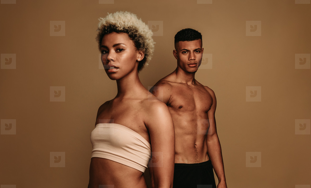 African american man and woman standing on brown background