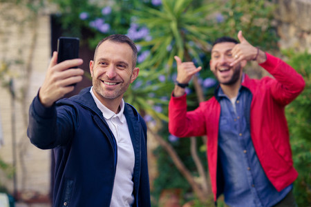 Gay couple making a funny selfie with their smartphone