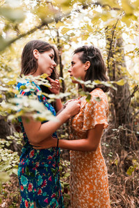 Two young lesbians caressing each other in the woods