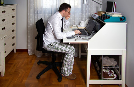 Man teleworking wearing shirt  tie and pajama pants