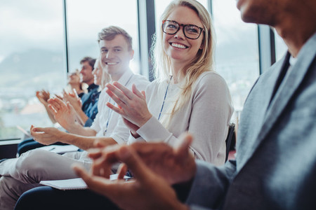 Group of businesspeople clapping hands at seminar