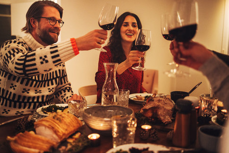 Happy family toasting wine and enjoying Christmas dinner