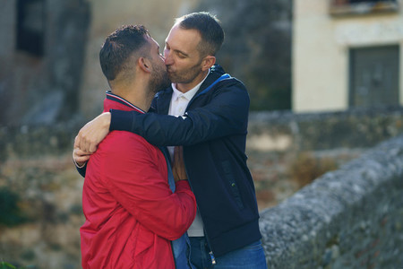 Gay couple kissing a beautiful place near the river