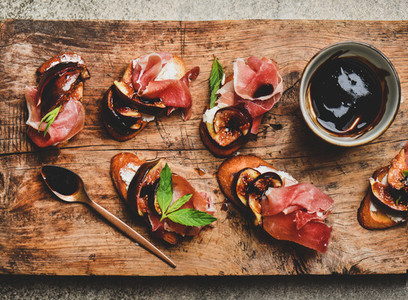 Crostini with prosciutto  cheese and figs on wooden board