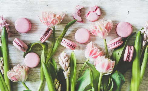 Sweet pink macaron cookies and spring fresh flowers  top view