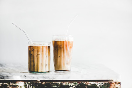 Iced latte coffee in glasses with straws  whate wall background