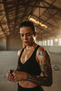 Muscular woman inside abandoned warehouse
