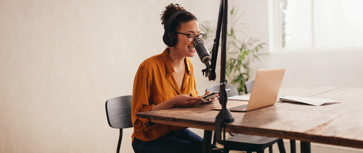 Woman recording a podcast from home studio