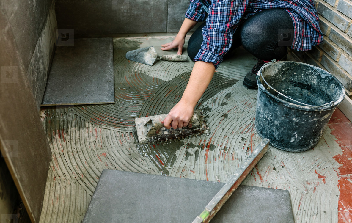 Female mason laying tiles on a terrace