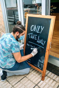 Restaurant owner writing on a blackboard