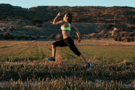 Woman runner running through the spring meadow  Workout in a nature