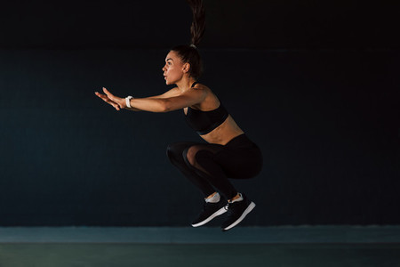 Side view of female athlete jump