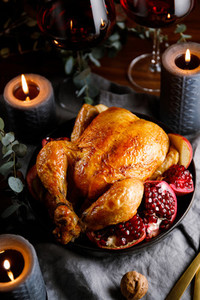 Whole roast chicken with pomegranate  apple and red wine on a festive table  Christmas or New Year cooking concept