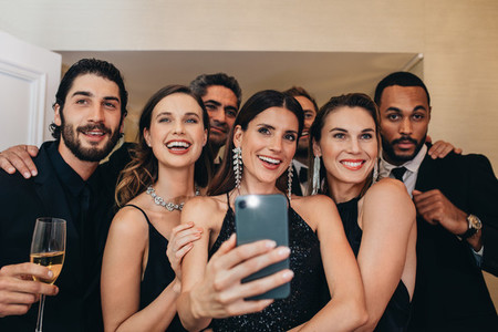 Multi ethnic group of people taking a selfie at a party