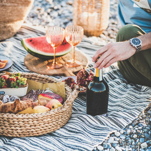 Couple having picnic with bottle of sparlking wine  square crop