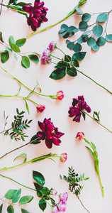Flat lay of various summer flowers over pink background  vertical composition
